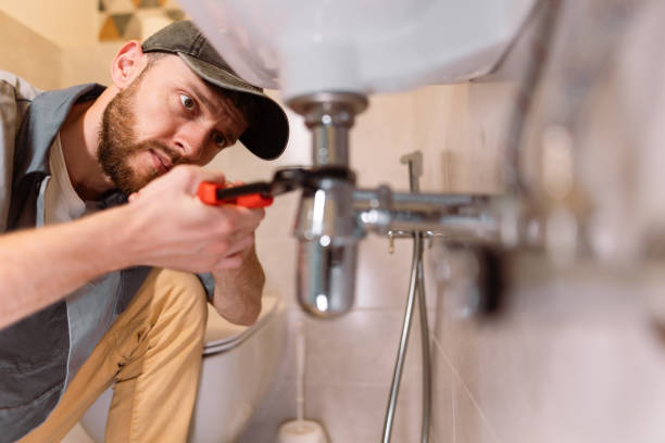 A plumber carefully fixes a leak in a sink using a wrench The plumber's careful approach highlights their professionalism and dedication to delivering high-quality service. They are equipped with the appropriate tools and materials, ensuring that the repair is done effectively and efficiently. The photo captures the importance of precision and attention to detail in plumbing work, as the plumber works to restore the functionality of the sink. plumbing services stock pictures, royalty-free photos & images