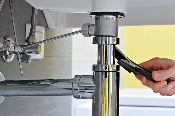 Close-up of plumber's hand doing repairing work at the sink Close-up of plumber's hand doing repairing work at the sink. plumbing services stock pictures, royalty-free photos & images