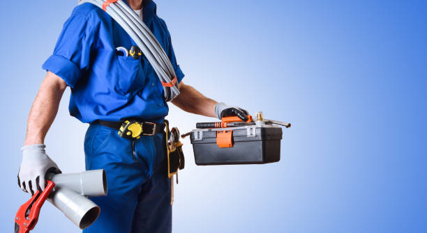 Detail of uniformed plumber with tools and blue isolated background Detail of uniformed plumber with work tools in hands and blue gradient isolated background. Side view. Horizontal composition. plumbing company stock pictures, royalty-free photos & images