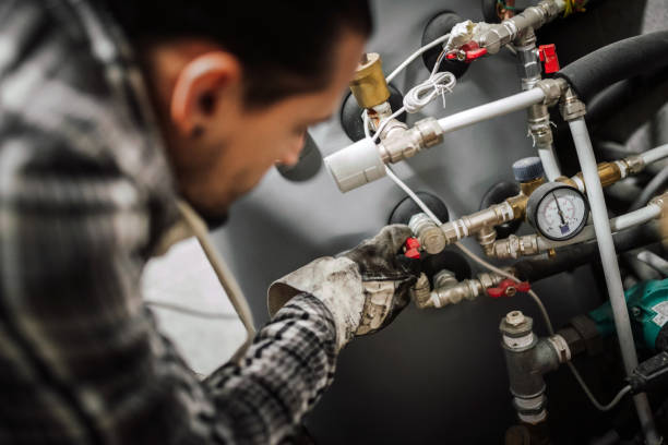 Heating engineer fixing modern heating system. Close up photo of a man fixing the pipes at home. plumbing stock pictures, royalty-free photos & images