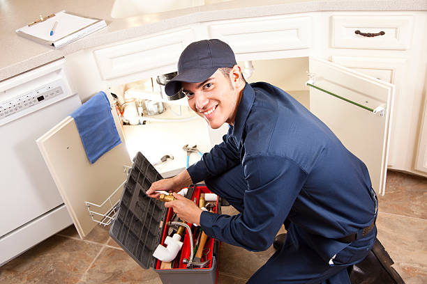 Latin Plumber, repairman working under sink, home kitchen. Service industry. Latin Plumber working under sink in kitchen. Service industry. Home repairman. plumbing service stock pictures, royalty-free photos & images