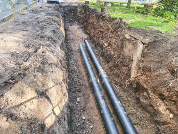 laying of underground communications for residential buildings. black plumbing pipes made of durable and reliable material are buried deep in an earthen ditch laying of underground communications for residential buildings. black plumbing pipes made of durable and reliable material are buried deep in an earthen ditch. Sewer Line Issues stock pictures, royalty-free photos & images