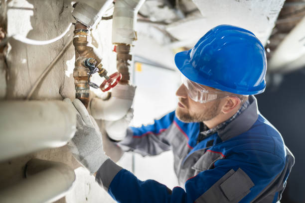 Male Worker Inspecting Valve Male Worker Inspecting Water Valve For Leaks In Basement plumbing services stock pictures, royalty-free photos & images