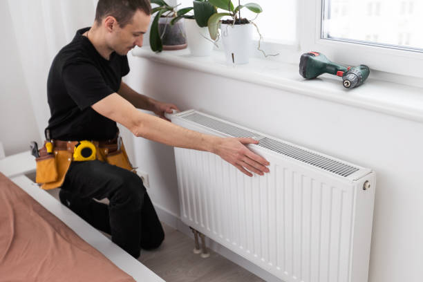 plumber at work. Installing water heating radiator plumber at work. Installing water heating radiator. High quality photo plumber stock pictures, royalty-free photos & images