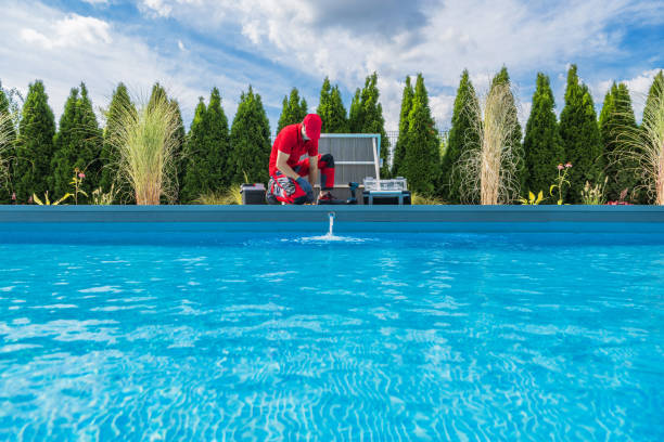 Professional Swimming Pools Technician Performing Seasonal Maintenance Professional Caucasian Swimming Pools Technician in His 40s Performing Seasonal Maintenance. Outdoor Residential Backyard Pool. pool stock pictures, royalty-free photos & images