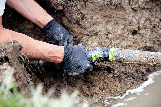 Repairing a Broken Pipe Plumber Repairing a Broken Pipe in a Septic Field plumbing issues stock pictures, royalty-free photos & images