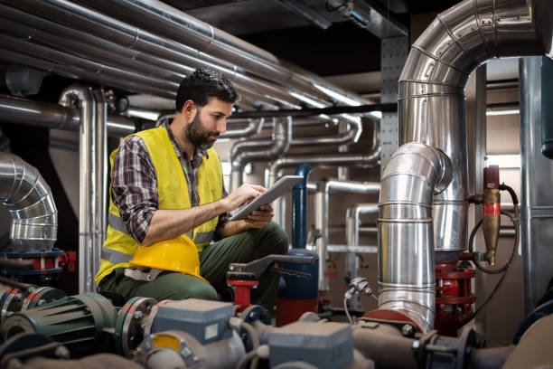 Stationary engineer at work Stationary engineer at work with technician support plumbing stock pictures, royalty-free photos & images