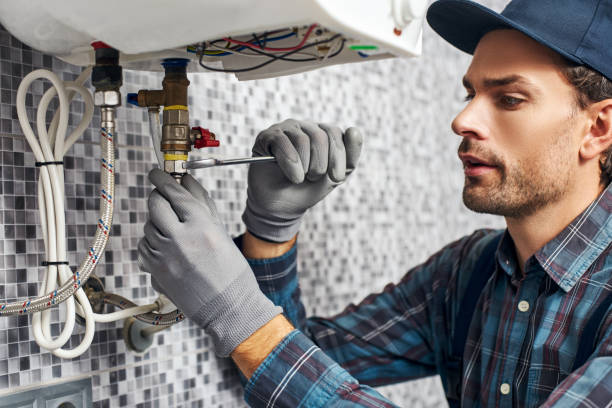 Wrench always with you. Worker set up electric heating boiler at home bathroom Wrench always with you. Worker set up electric heating boiler at home. Close-up of young handyman plumbing services stock pictures, royalty-free photos & images